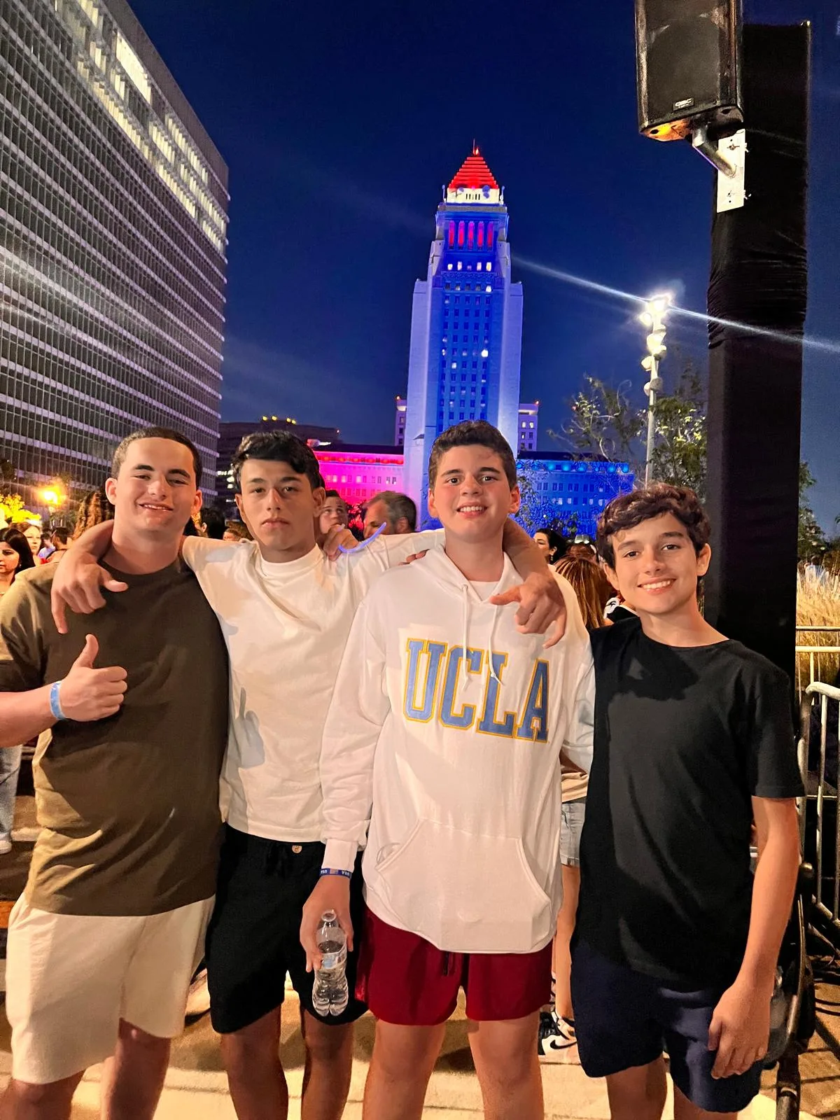 Students at an evening event in downtown Los Angeles, with Los Angeles City Hall lit up behind them