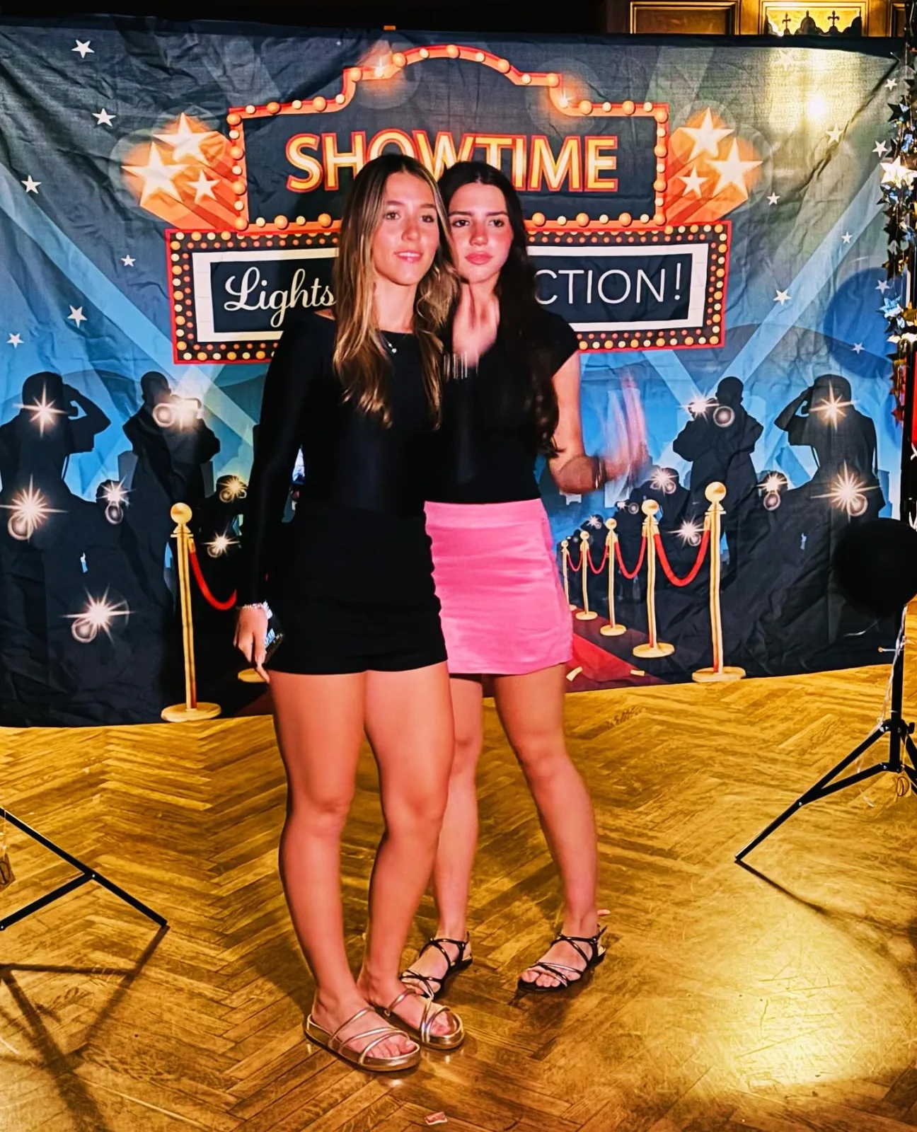 Two students dressed up in front of a Showtime photo backdrop at an ELC evening event