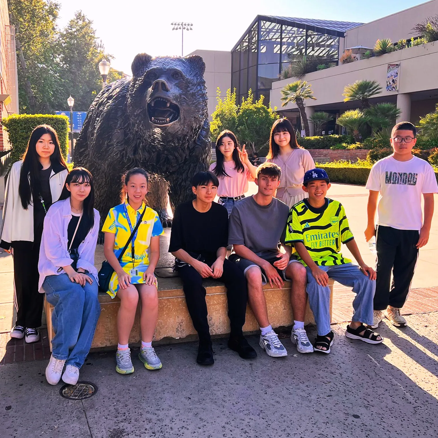 A group of ELC students sitting beside the Bruin Bear statue at UCLA