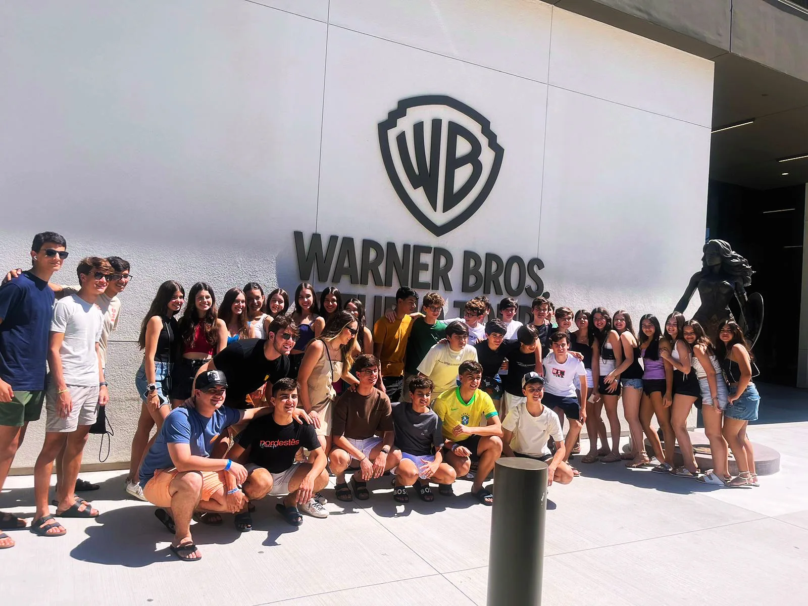A large group of ELC students in front of the Warner Bros. Studios sign in Los Angeles