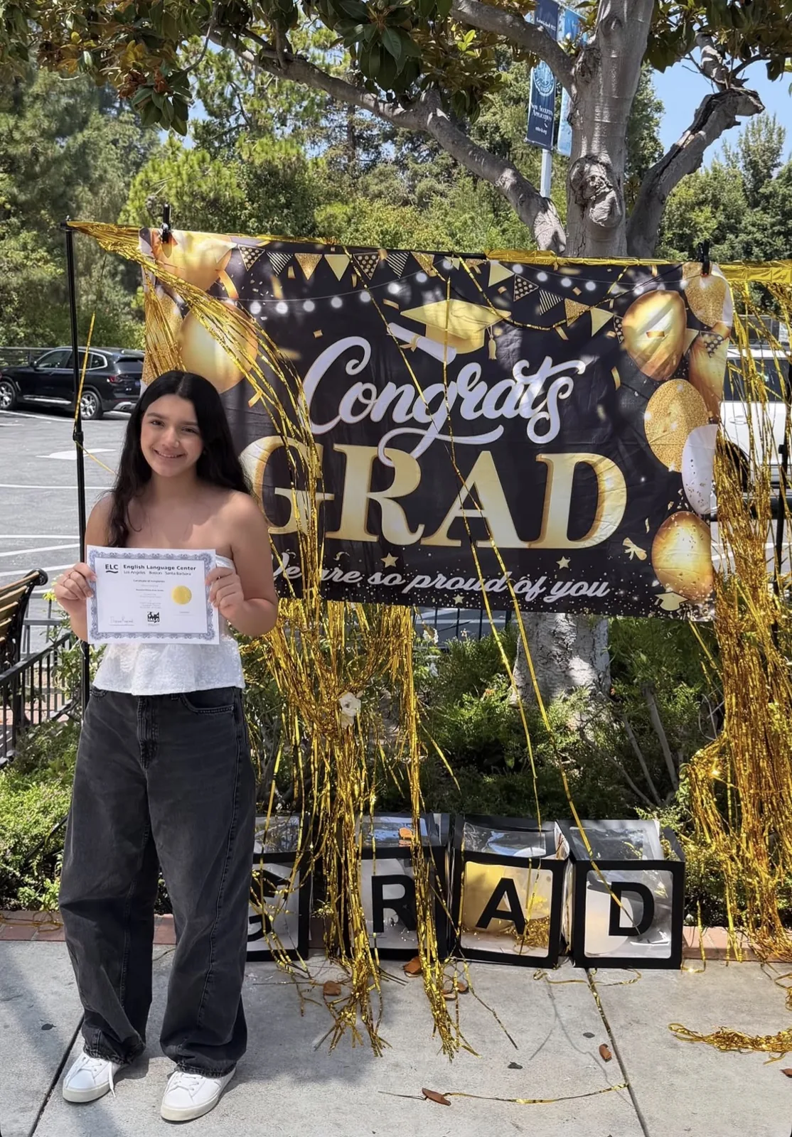 An ELC student holding her completion certificate on graduation day