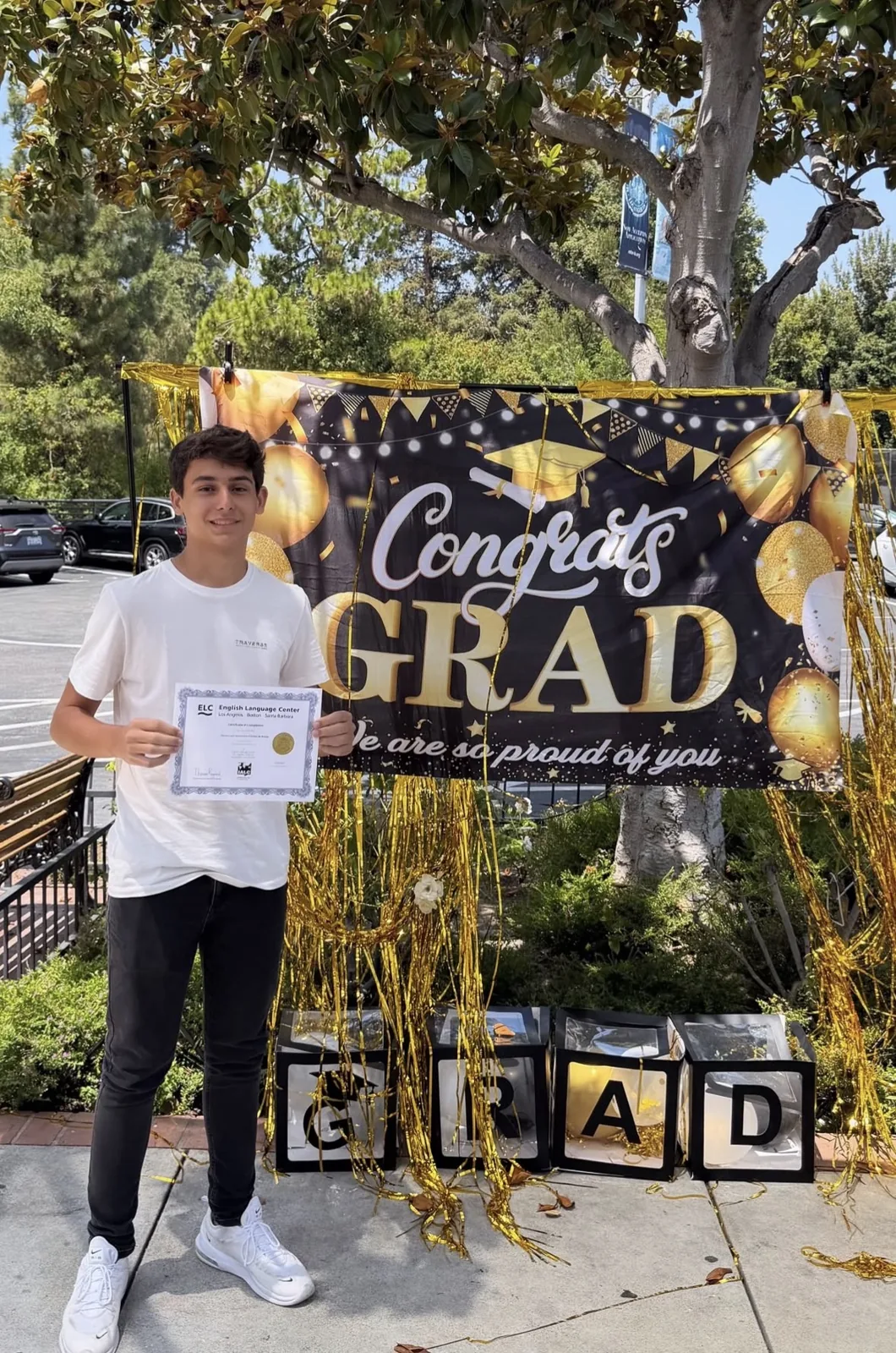 An ELC student holding his completion certificate on graduation day