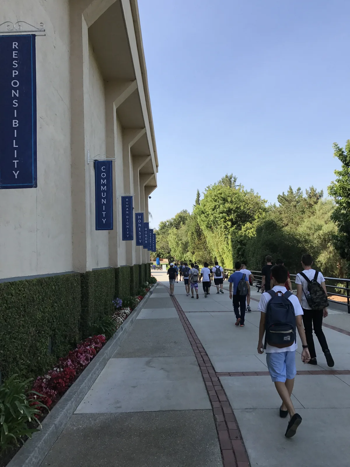 Students walking to class with staff across campus